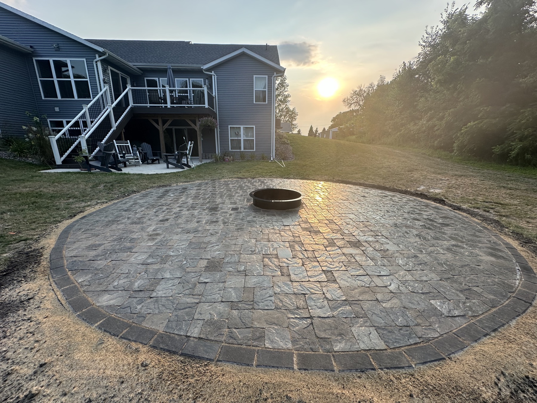 Completed outdoor living space with hardscape and landscaping by Precision Property Works